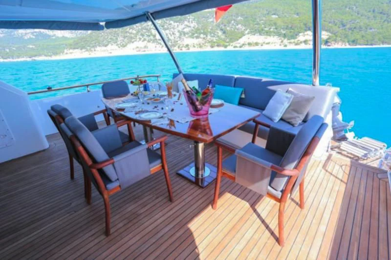 a table and chairs on a deck aboard ERDOGAN Yacht for Sale