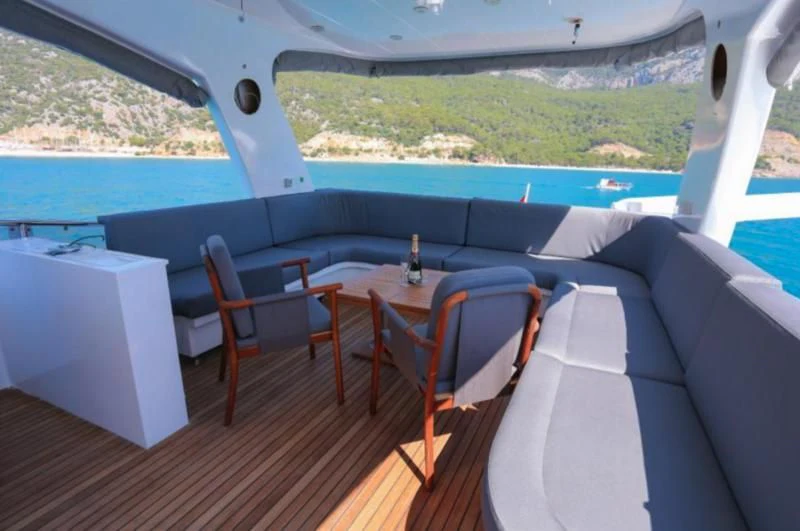 a deck with a table and chairs aboard ERDOGAN Yacht for Sale