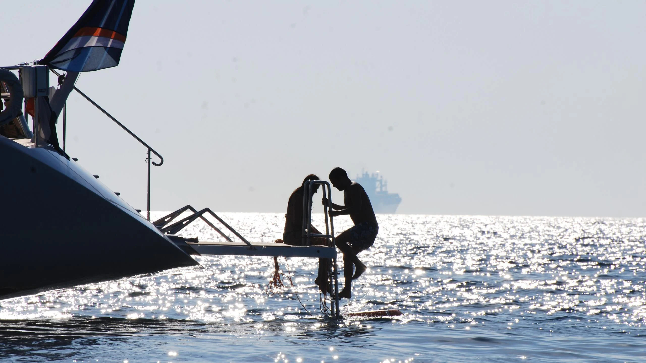 a man on a boat with a flag aboard HYPERION Yacht for Charter