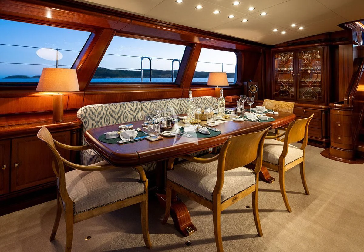 a table set with chairs and a window aboard HYPERION Yacht for Charter