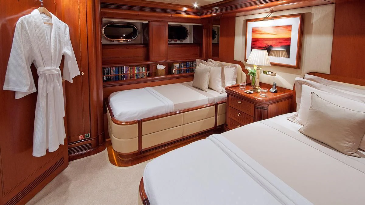a room with a bed and a television aboard HYPERION Yacht for Charter