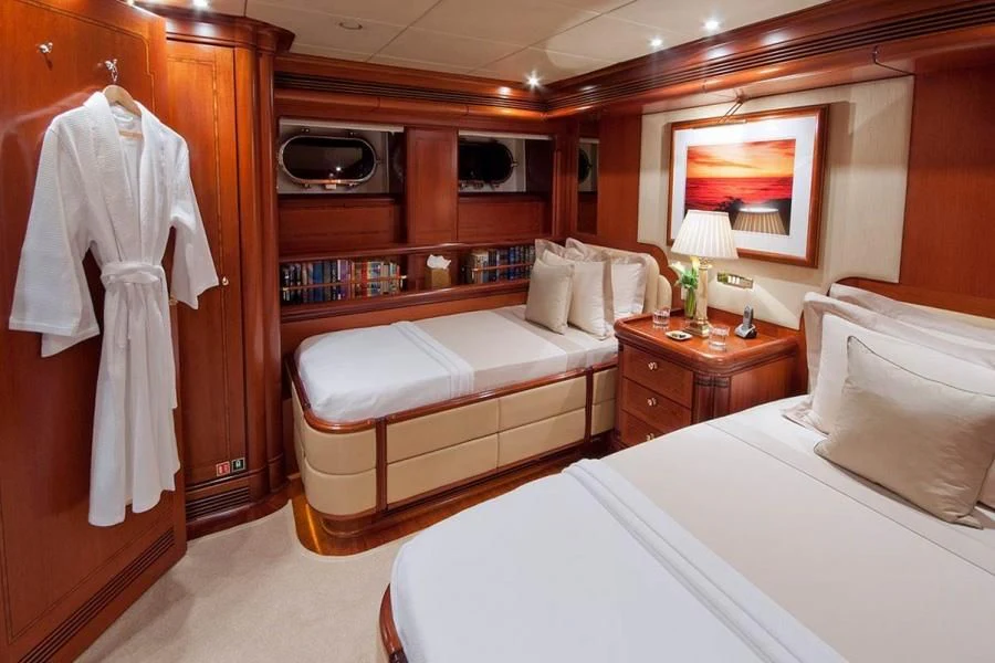 a room with a bed and a television aboard HYPERION Yacht for Charter