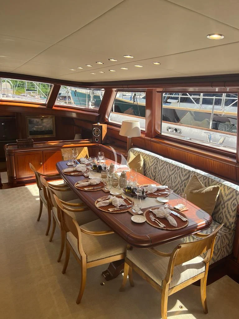 a dining table with plates and glasses aboard HYPERION Yacht for Charter