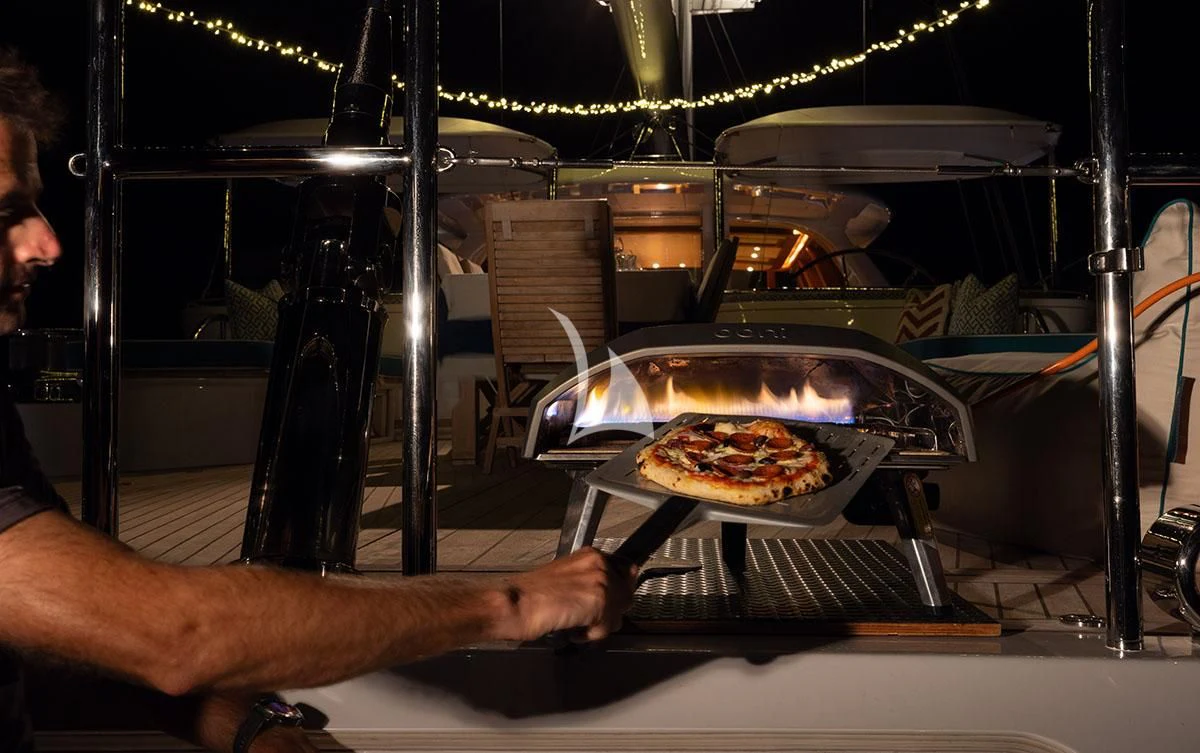 a person holding a pizza aboard HYPERION Yacht for Charter