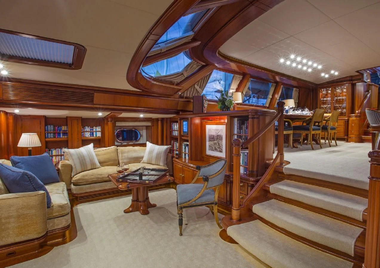 a living room with a wood table and couches aboard HYPERION Yacht for Charter