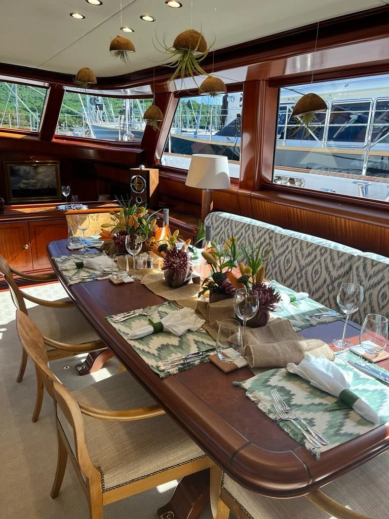 a dining table with a flower vase aboard HYPERION Yacht for Charter