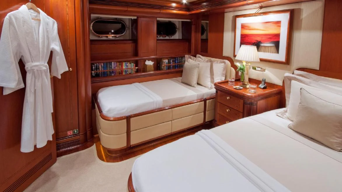 a room with beds and a television aboard HYPERION Yacht for Charter