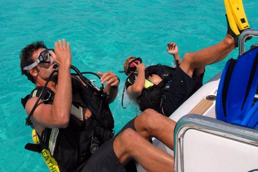 a man and woman in scuba gear on a boat aboard HYPERION Yacht for Charter