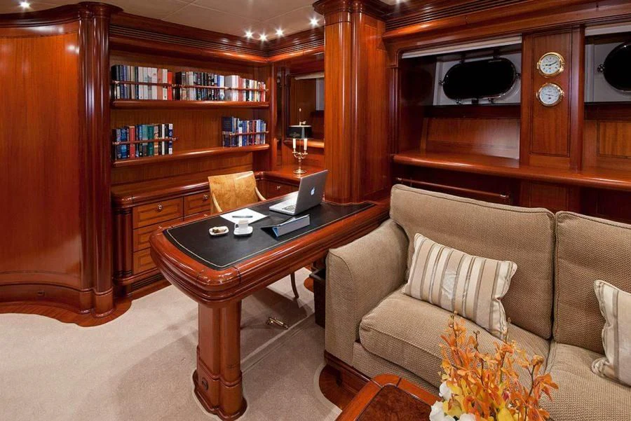a living room with a laptop on a coffee table aboard HYPERION Yacht for Charter