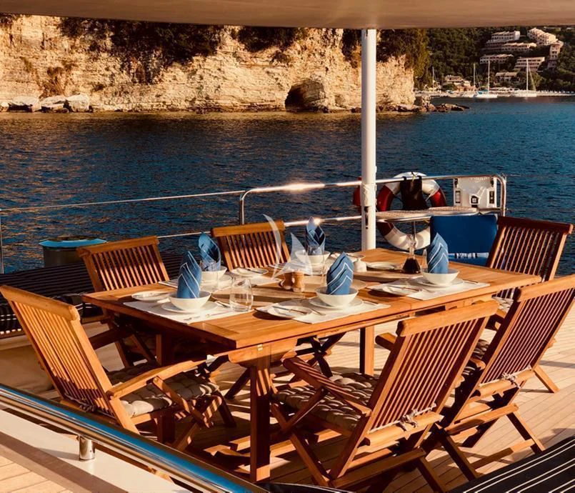 a table with chairs on it by the water aboard HYPERION Yacht for Charter