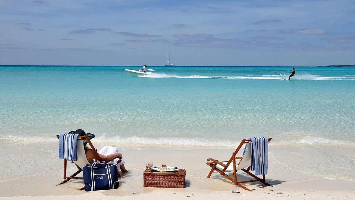 a couple of people sit on chairs on a beach aboard HYPERION Yacht for Charter