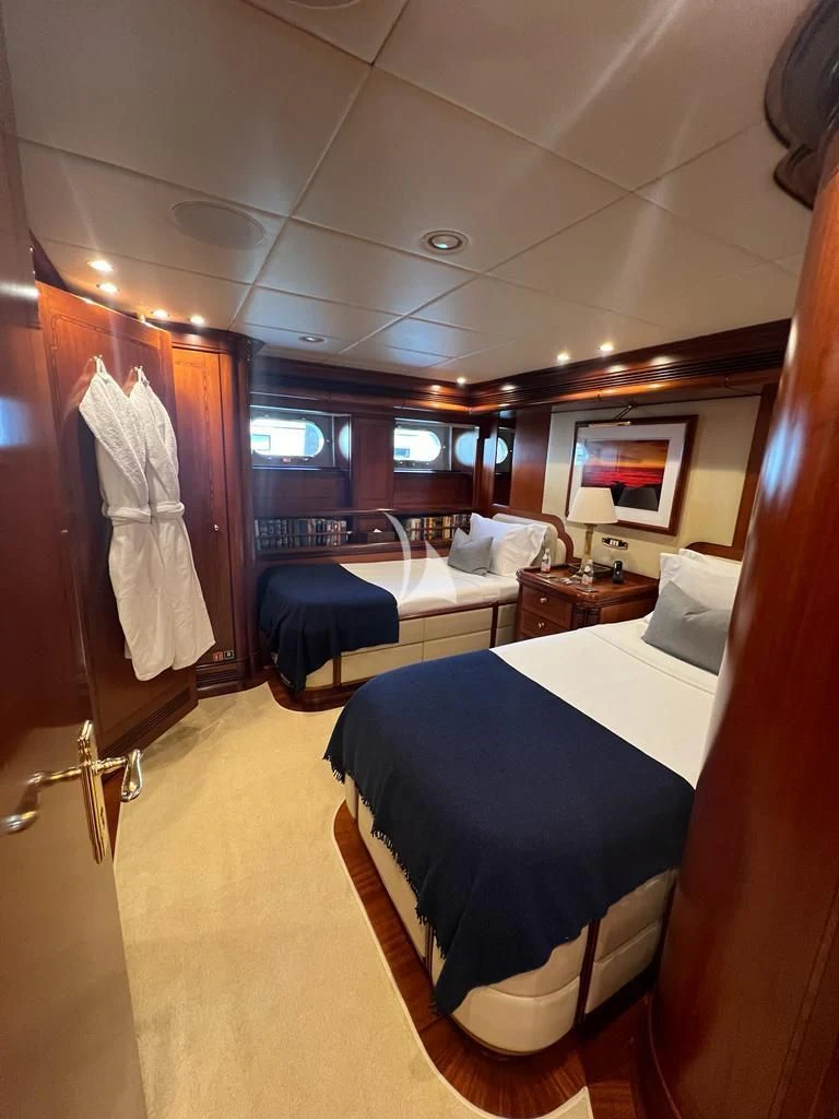 a room with a bed and a desk aboard HYPERION Yacht for Charter