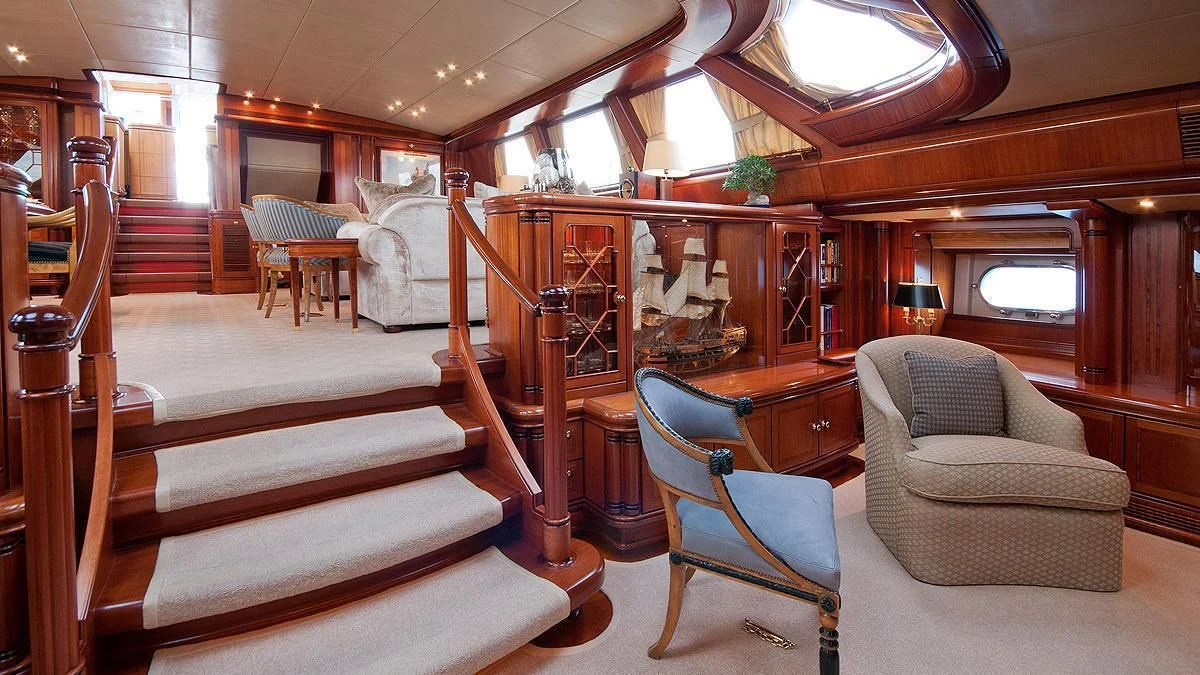 a room with a bed and chairs aboard HYPERION Yacht for Charter