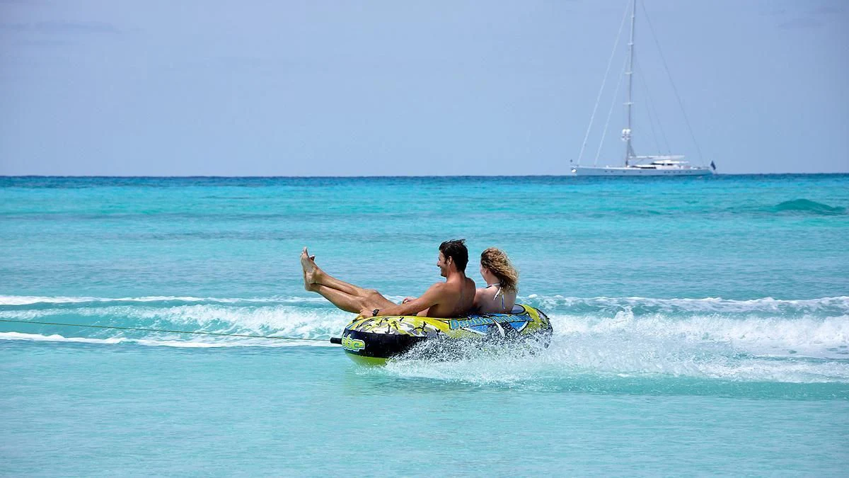 a man and a woman on a surfboard in the ocean aboard HYPERION Yacht for Charter