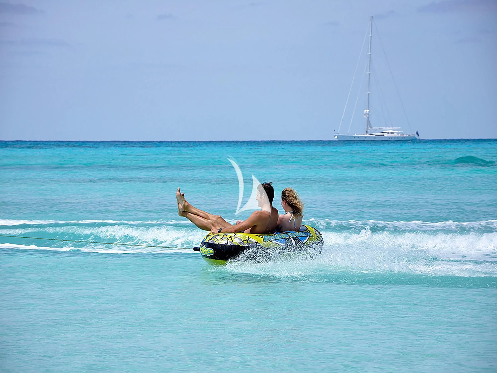 a man lying on a surfboard in the ocean aboard HYPERION Yacht for Charter