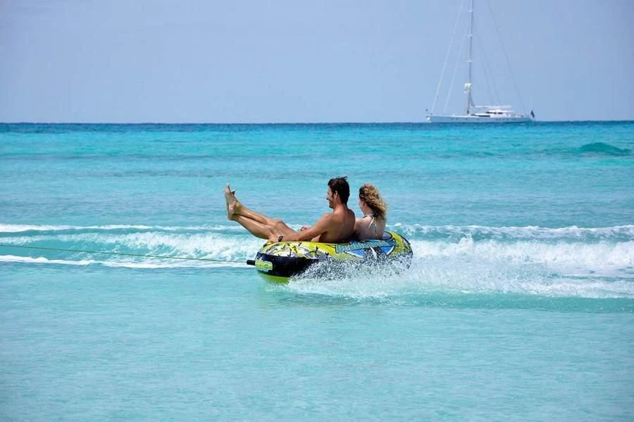 a man and a woman lying on a surfboard in the ocean aboard HYPERION Yacht for Charter