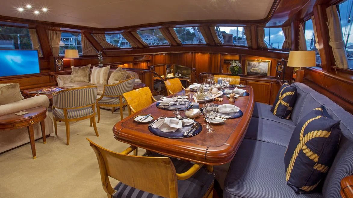 a large living room with a large table and chairs aboard HYPERION Yacht for Charter