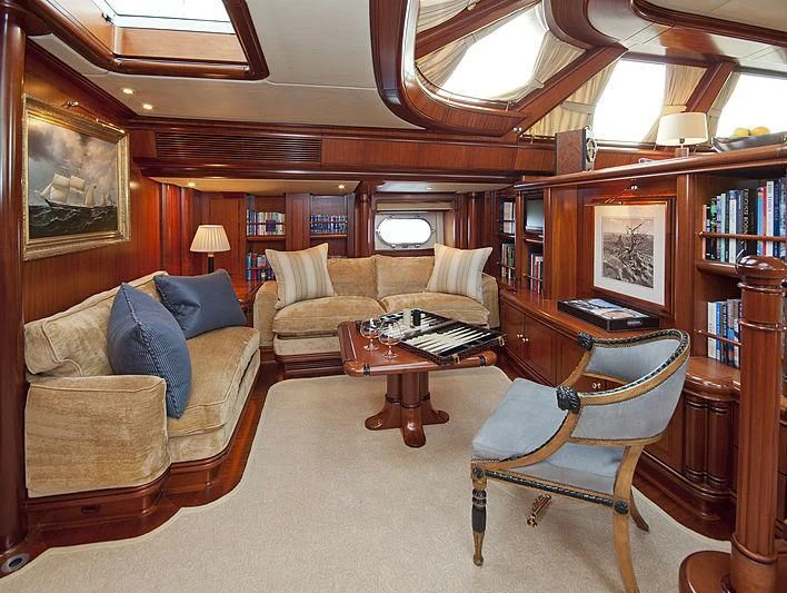 a living room with a couch and a book shelf aboard HYPERION Yacht for Charter
