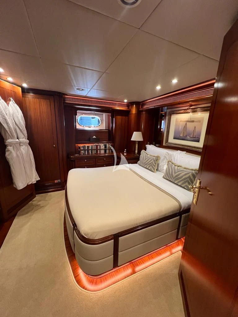 a bedroom with a bed and a tv on the wall aboard HYPERION Yacht for Charter