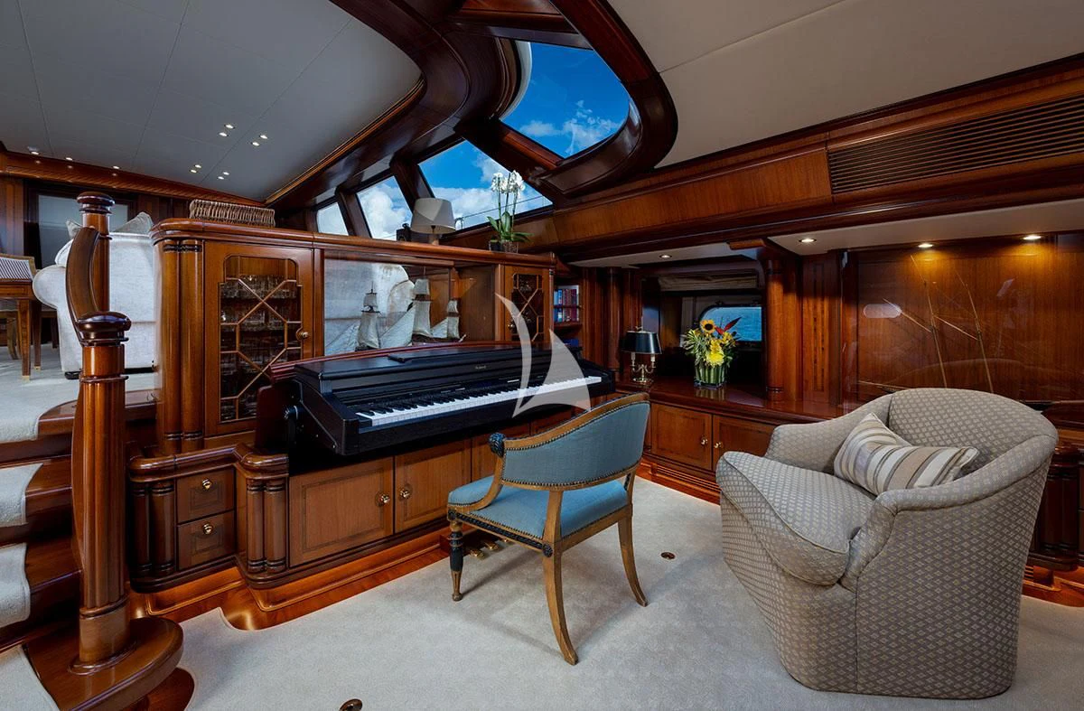 a room with a piano and a chair aboard HYPERION Yacht for Charter