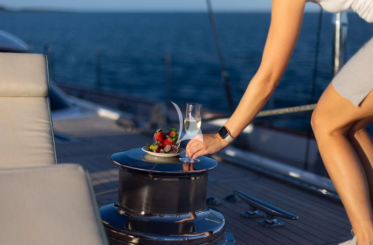 a woman pouring a glass of wine on a boat aboard HYPERION Yacht for Charter