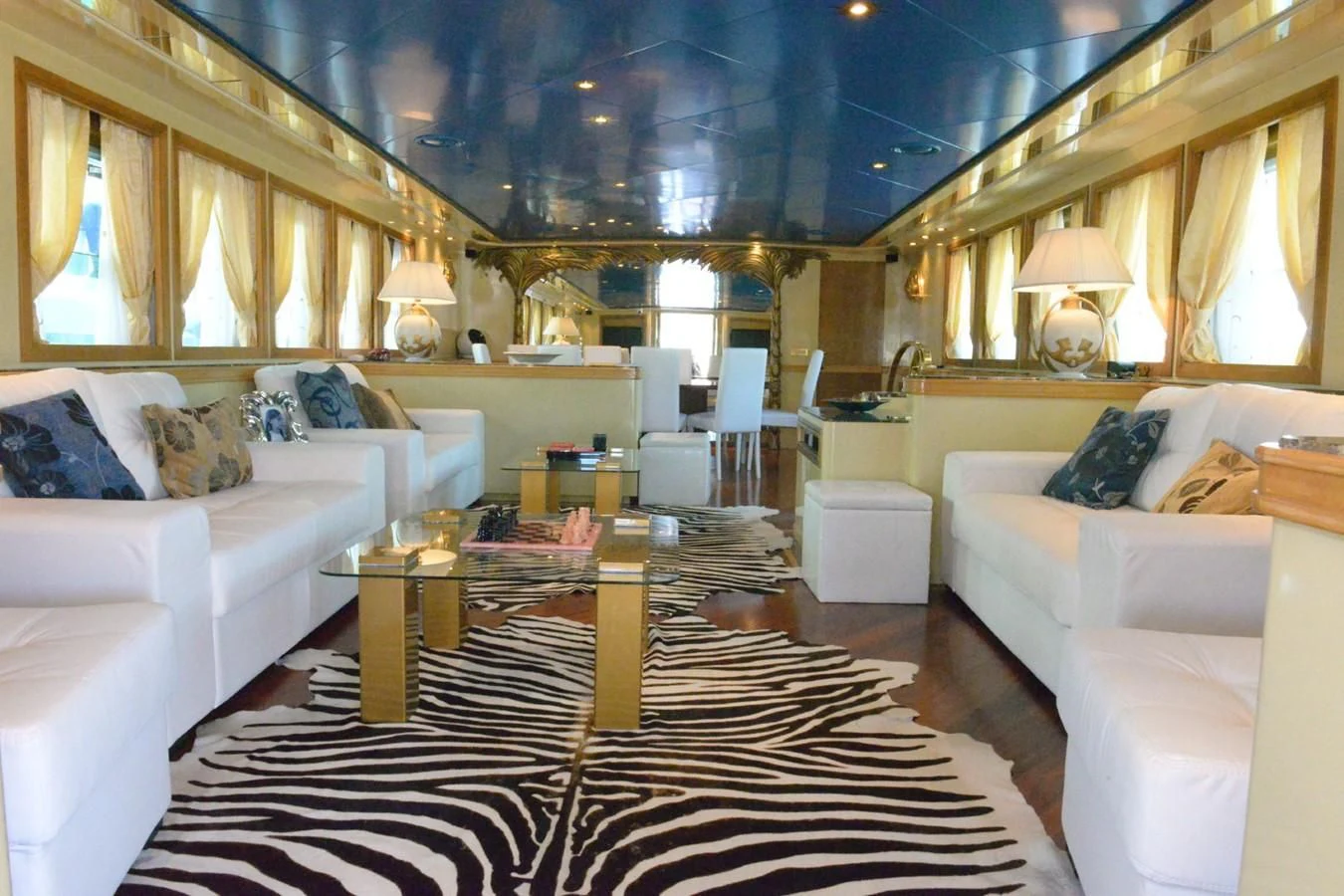 a large living room with white couches and a black and white checkered rug aboard MISTER P Yacht for Sale