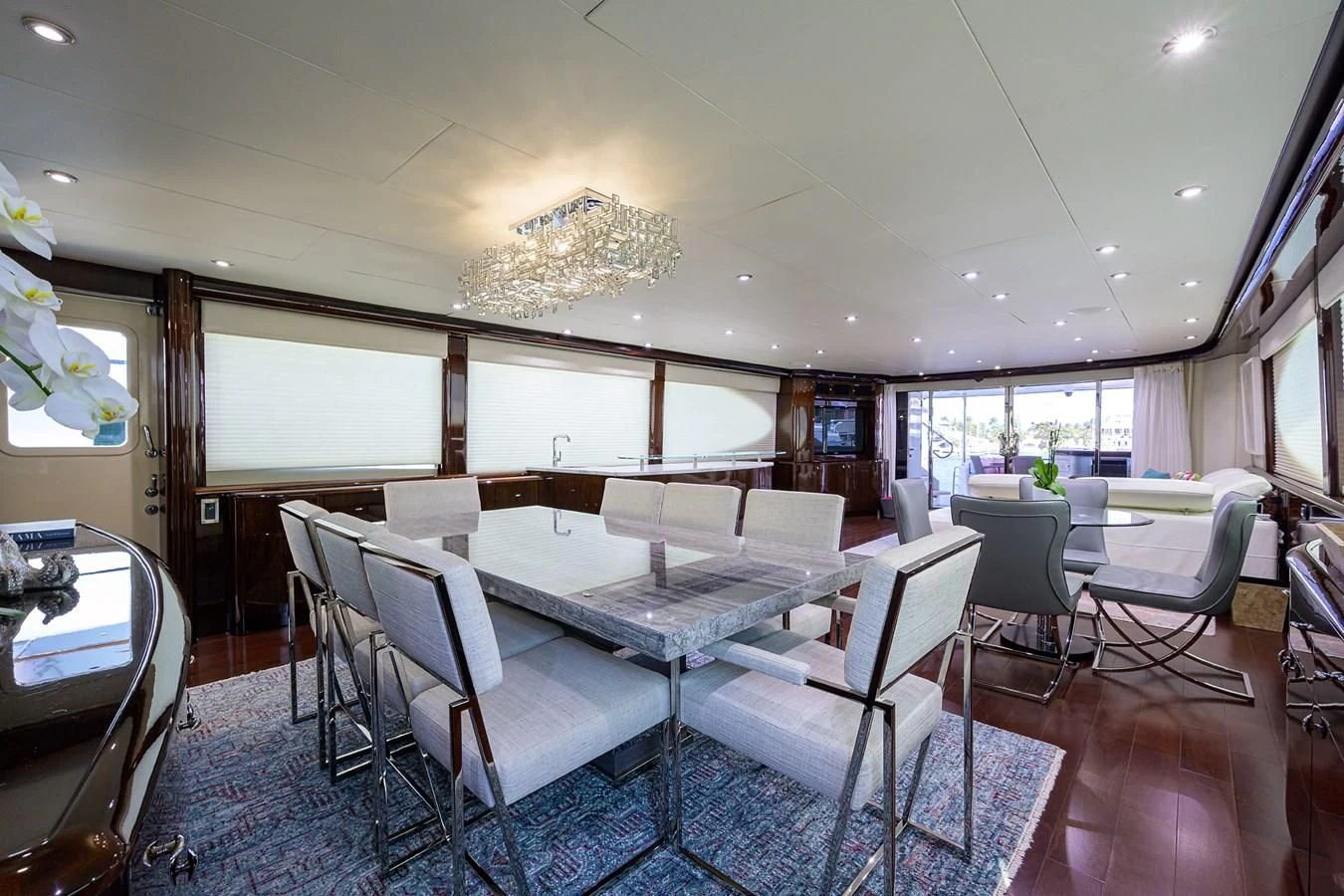 a room with a table chairs and a chandelier aboard THE JOB FATHER Yacht for Sale
