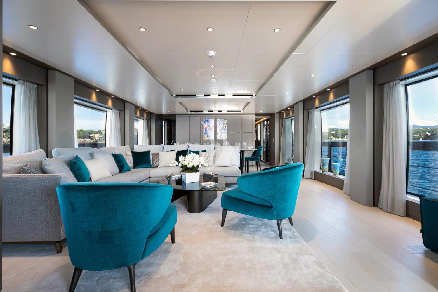 a living room with blue chairs aboard JAG'B Yacht for Sale