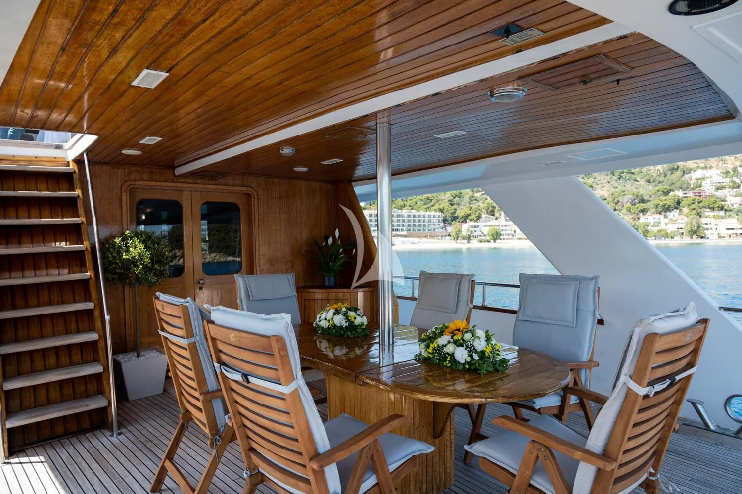a wood paneled dining room with a large open window aboard ELENA Yacht for Sale