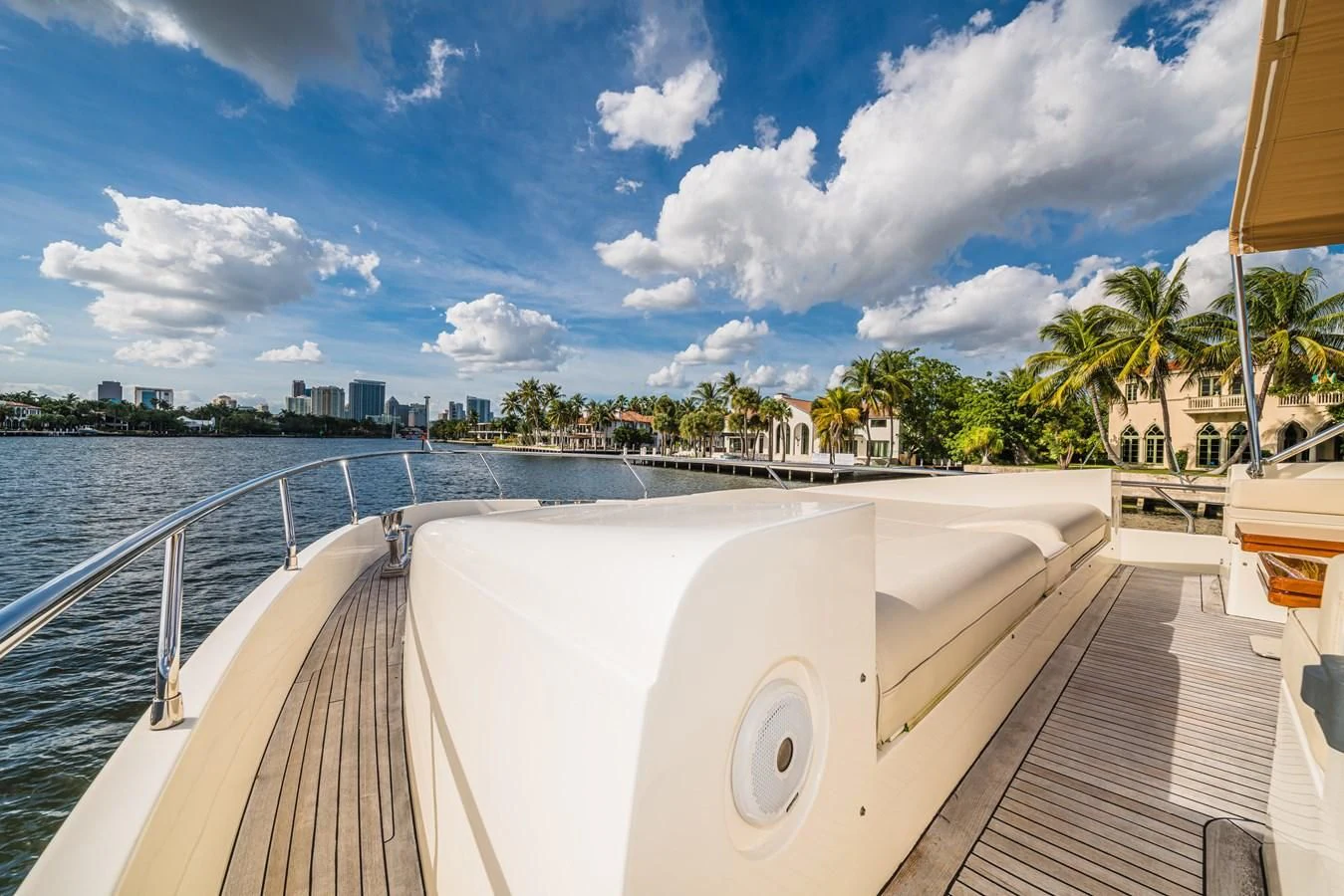 a deck with a large pool and trees and buildings in the background aboard LIBERTY BLUE Yacht for Sale