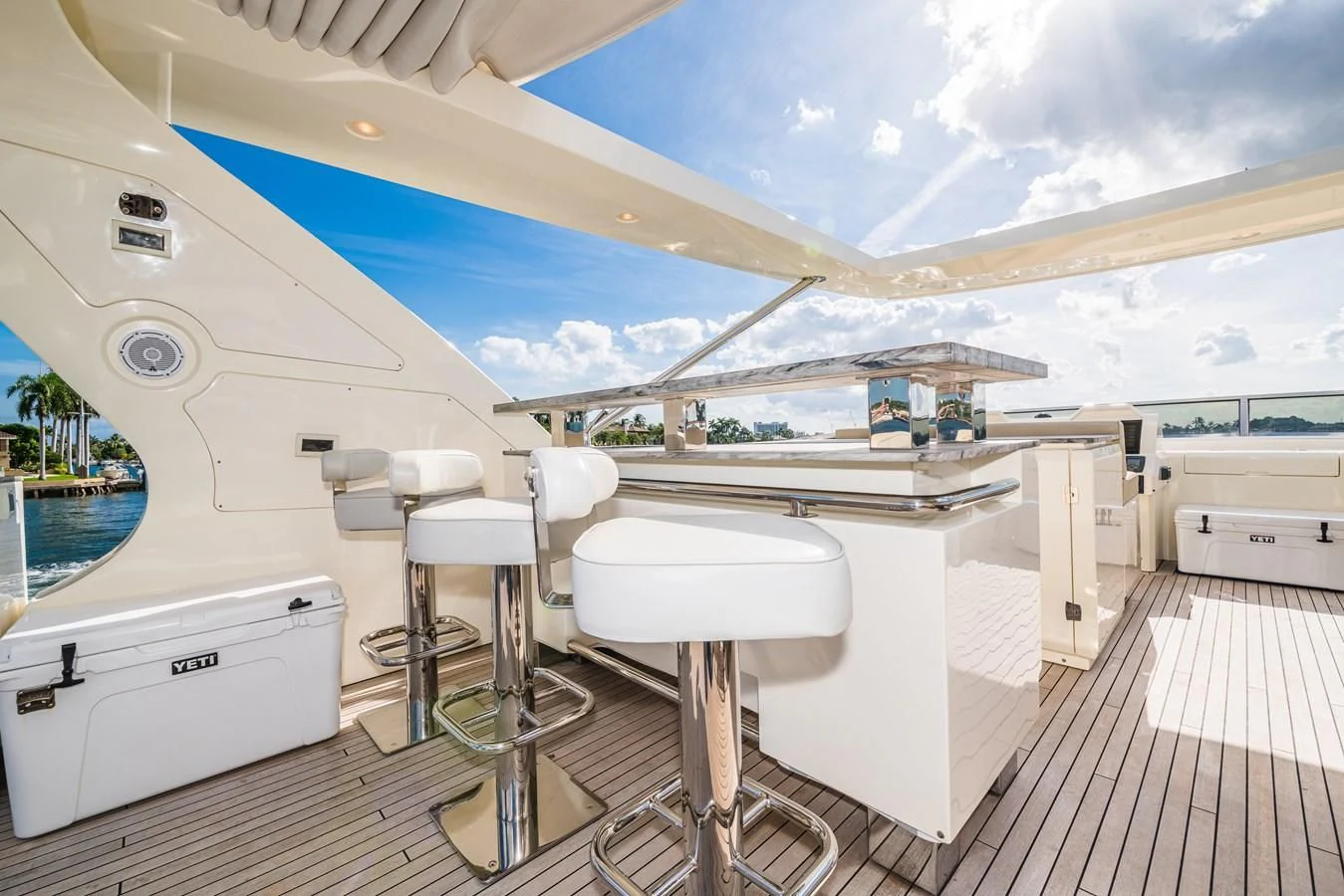 a white boat with stools and a table in a room with a view of the water and aboard LIBERTY BLUE Yacht for Sale