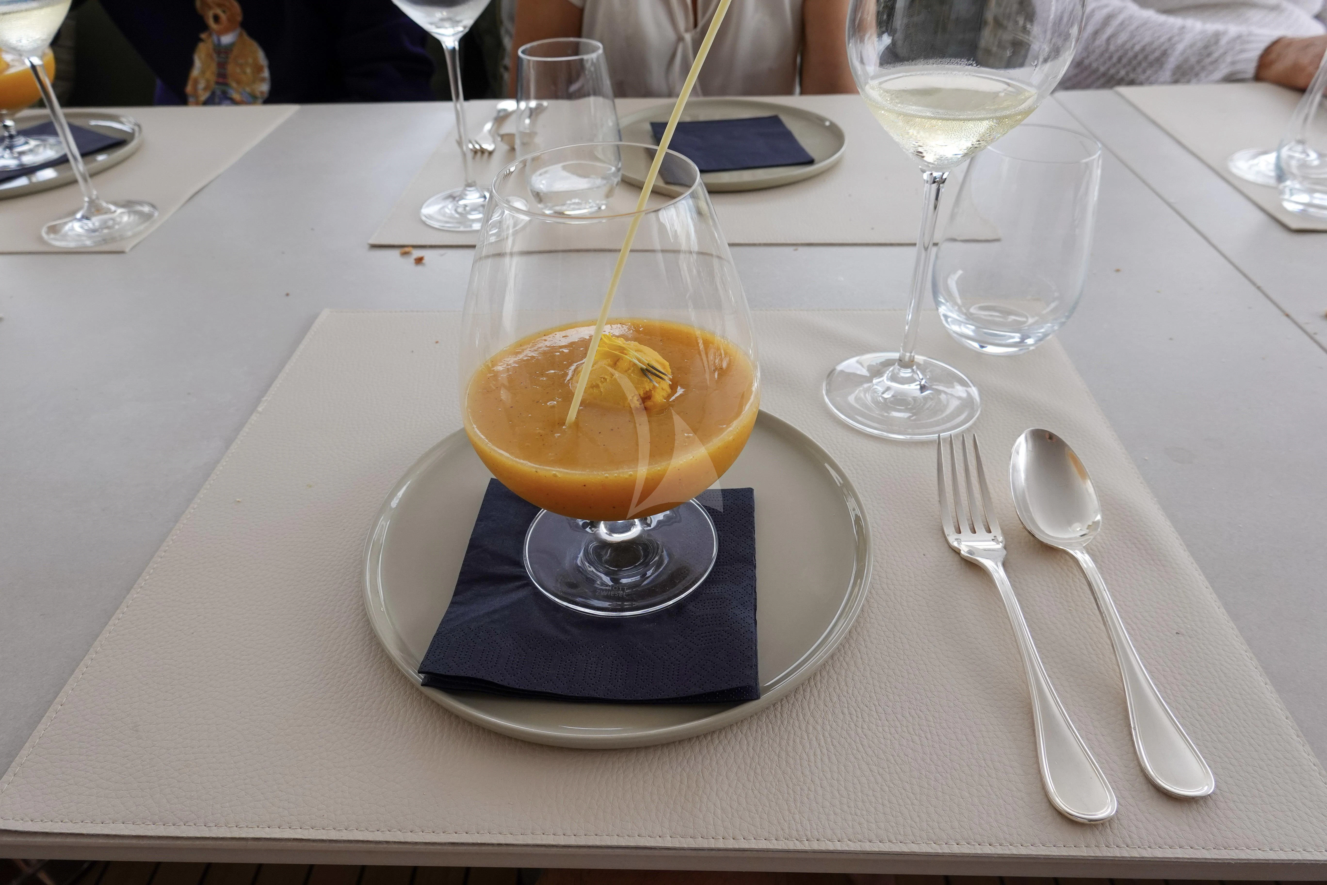 a glass of orange juice on a table aboard UNEXPECTED Yacht for Sale