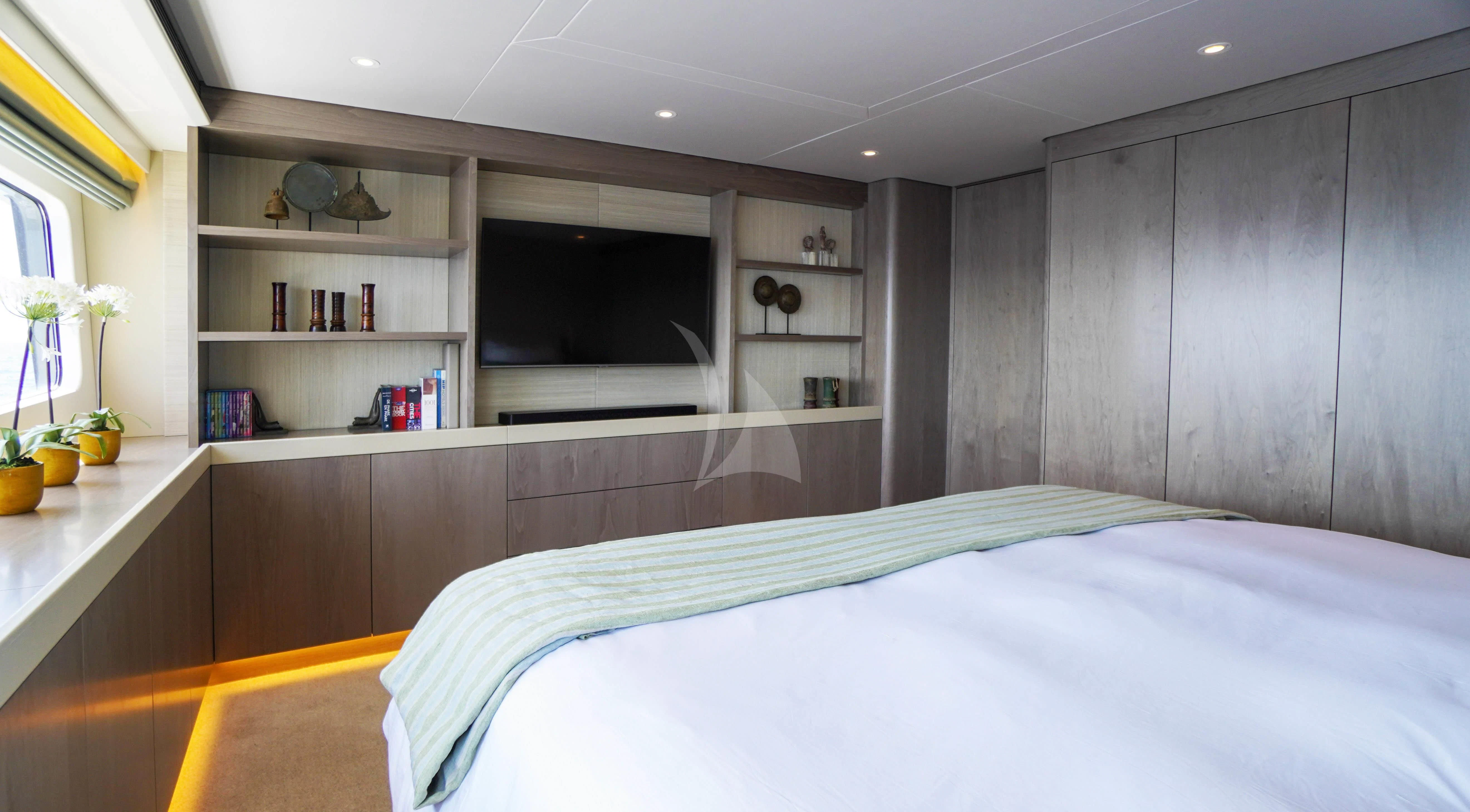 a bedroom with a bed and a shelf aboard UNEXPECTED Yacht for Sale