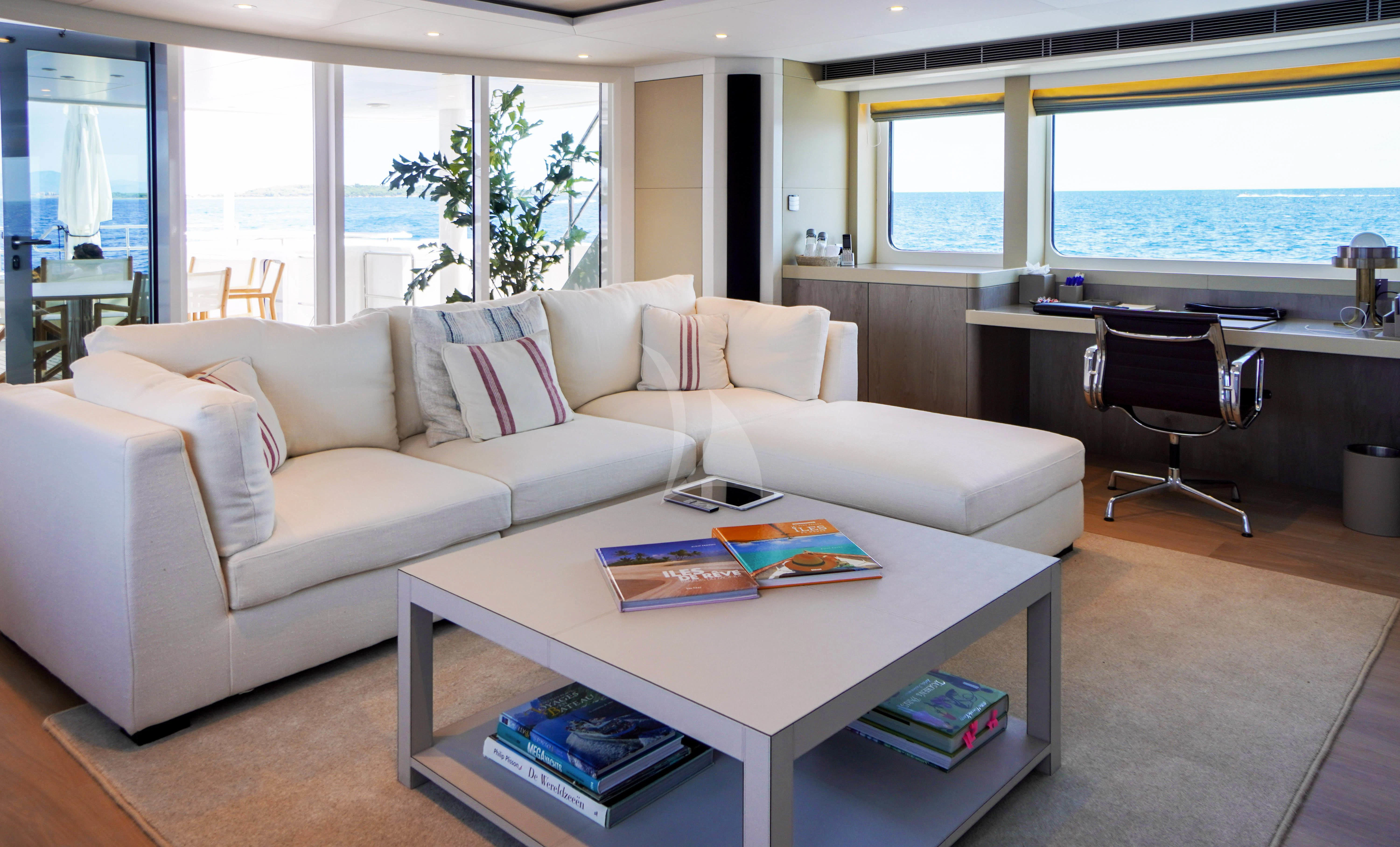 a living room with a couch and a table aboard UNEXPECTED Yacht for Sale