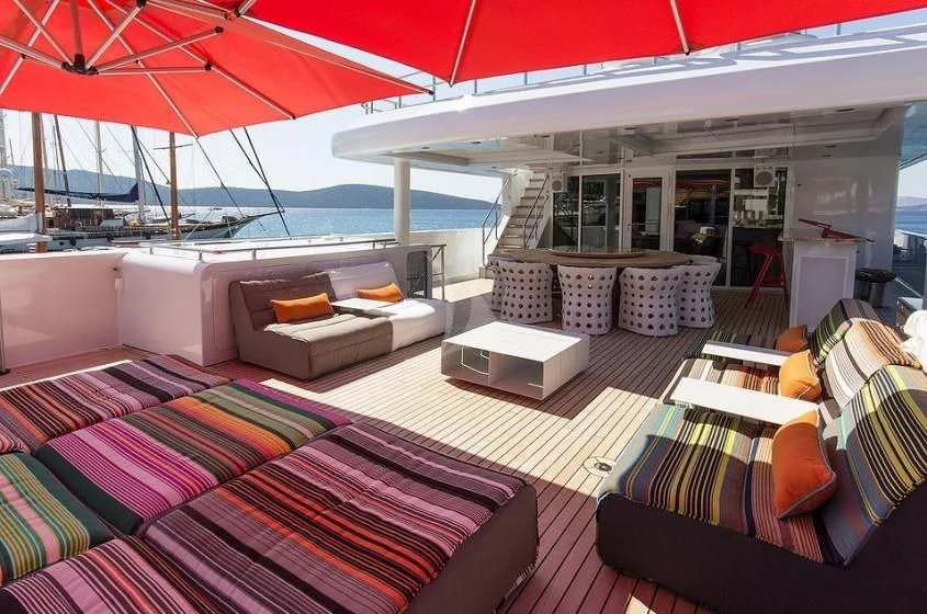a boat with a couch and a table on the deck aboard UNEXPECTED Yacht for Sale
