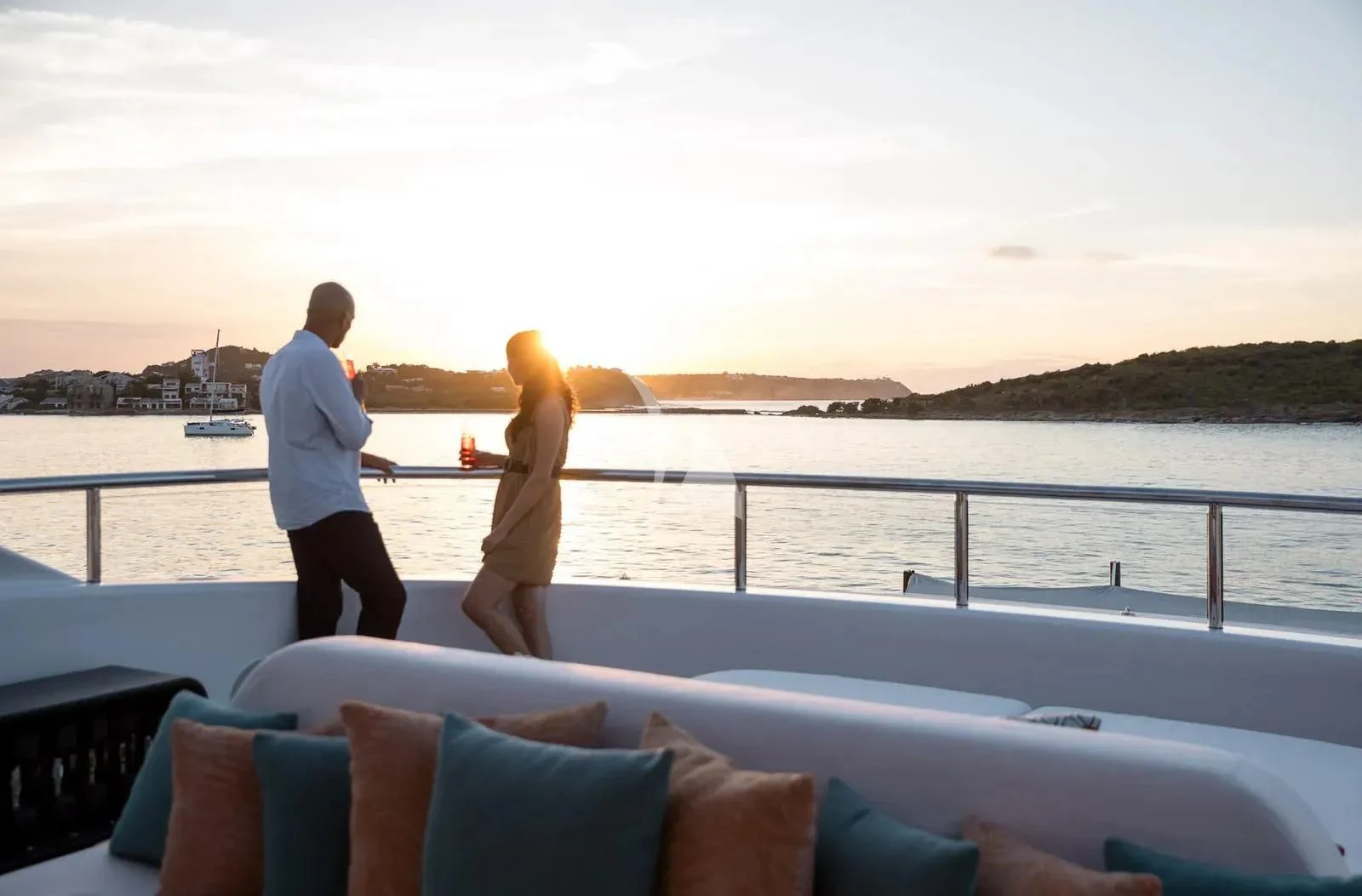 a man and woman walking on a boat with a body of water in the background aboard BIRUBI Yacht for Sale