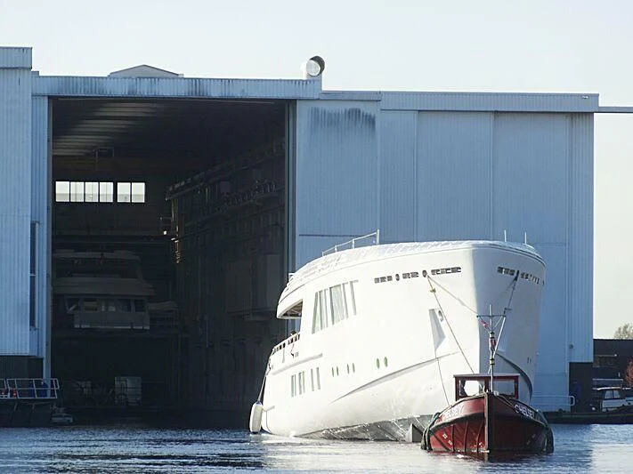 a large white boat sits in front of a building aboard CALLISTO Yacht for Sale