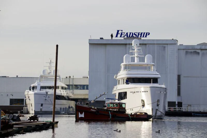 a large white building next to a boat in the water aboard CALLISTO Yacht for Sale
