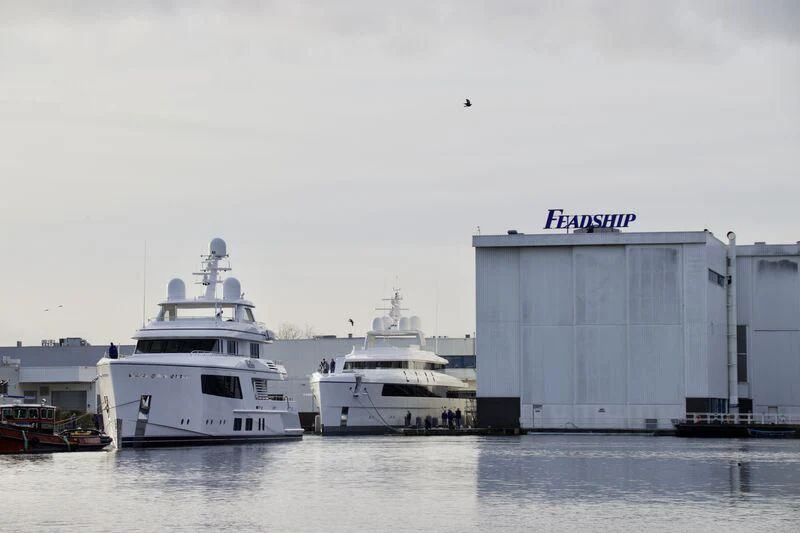 a couple of large white boats sit in a harbor aboard CALLISTO Yacht for Sale