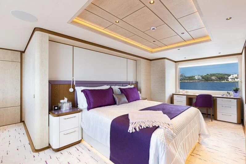 a bedroom with a bed and a desk aboard CALLISTO Yacht for Sale