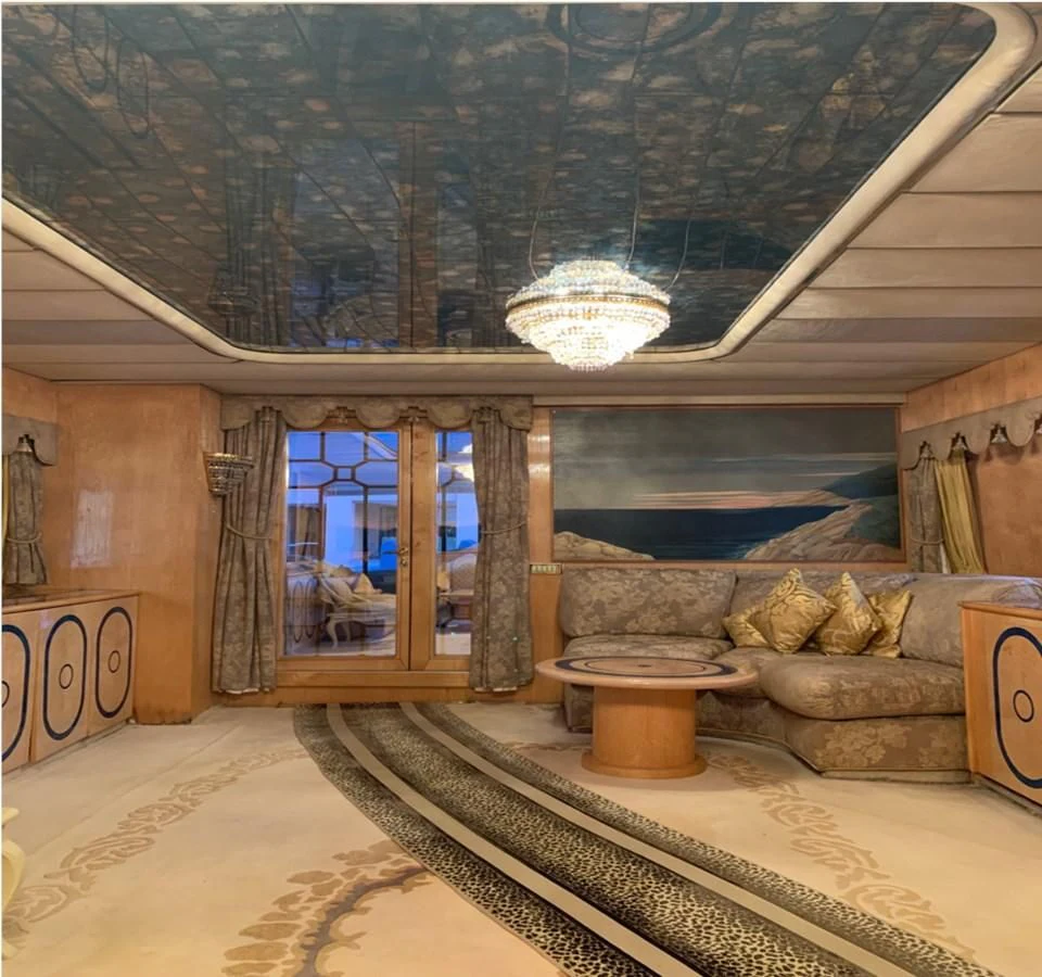 a room with a large window and a large stone fireplace aboard BAHIRA II Yacht for Sale