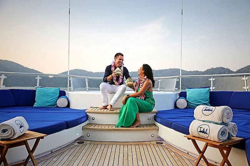 a man and woman sitting on a boat aboard TALISMAN MAITON Yacht for Charter