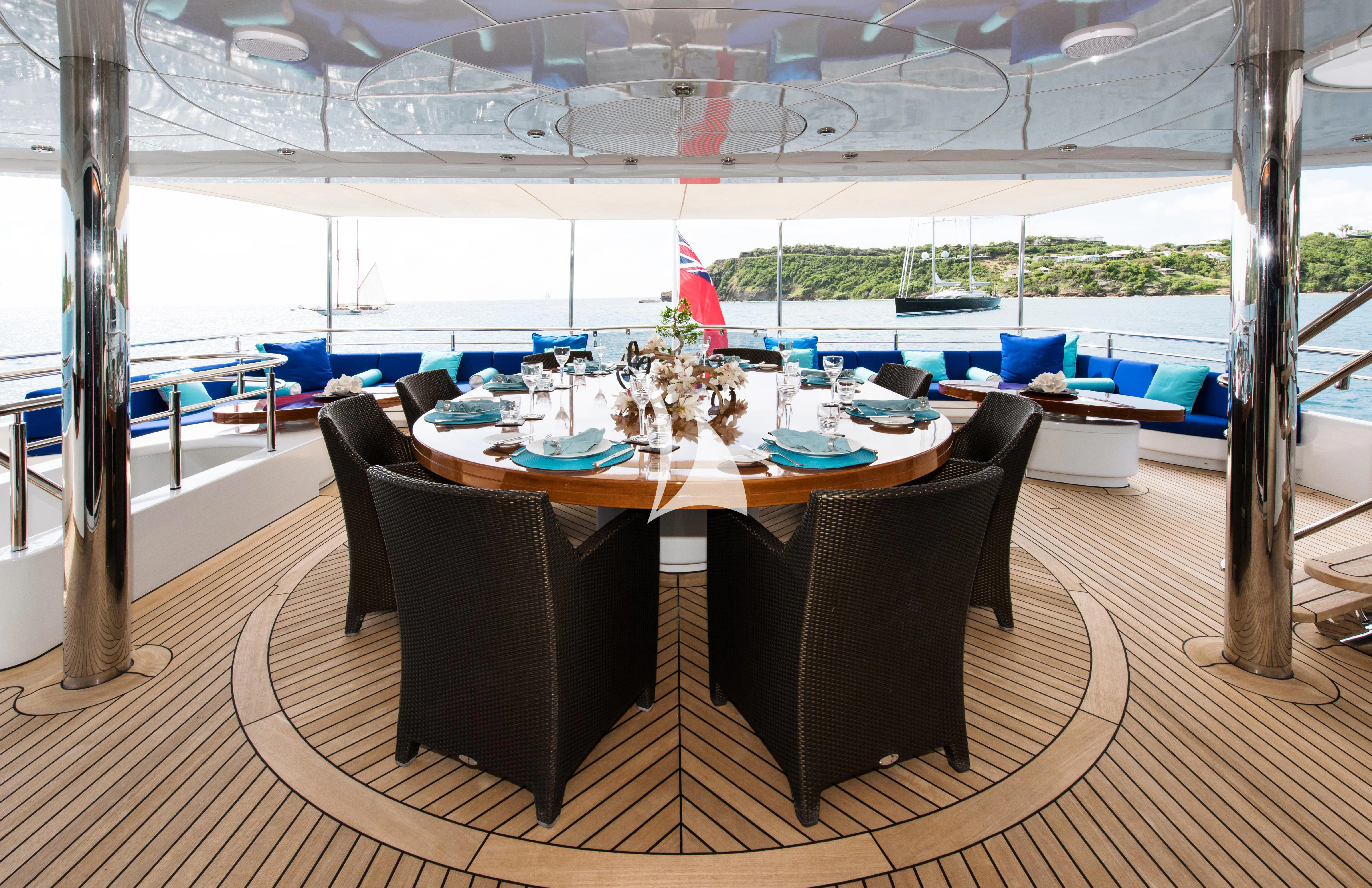 a dining table with chairs and a large window aboard TALISMAN MAITON Yacht for Charter