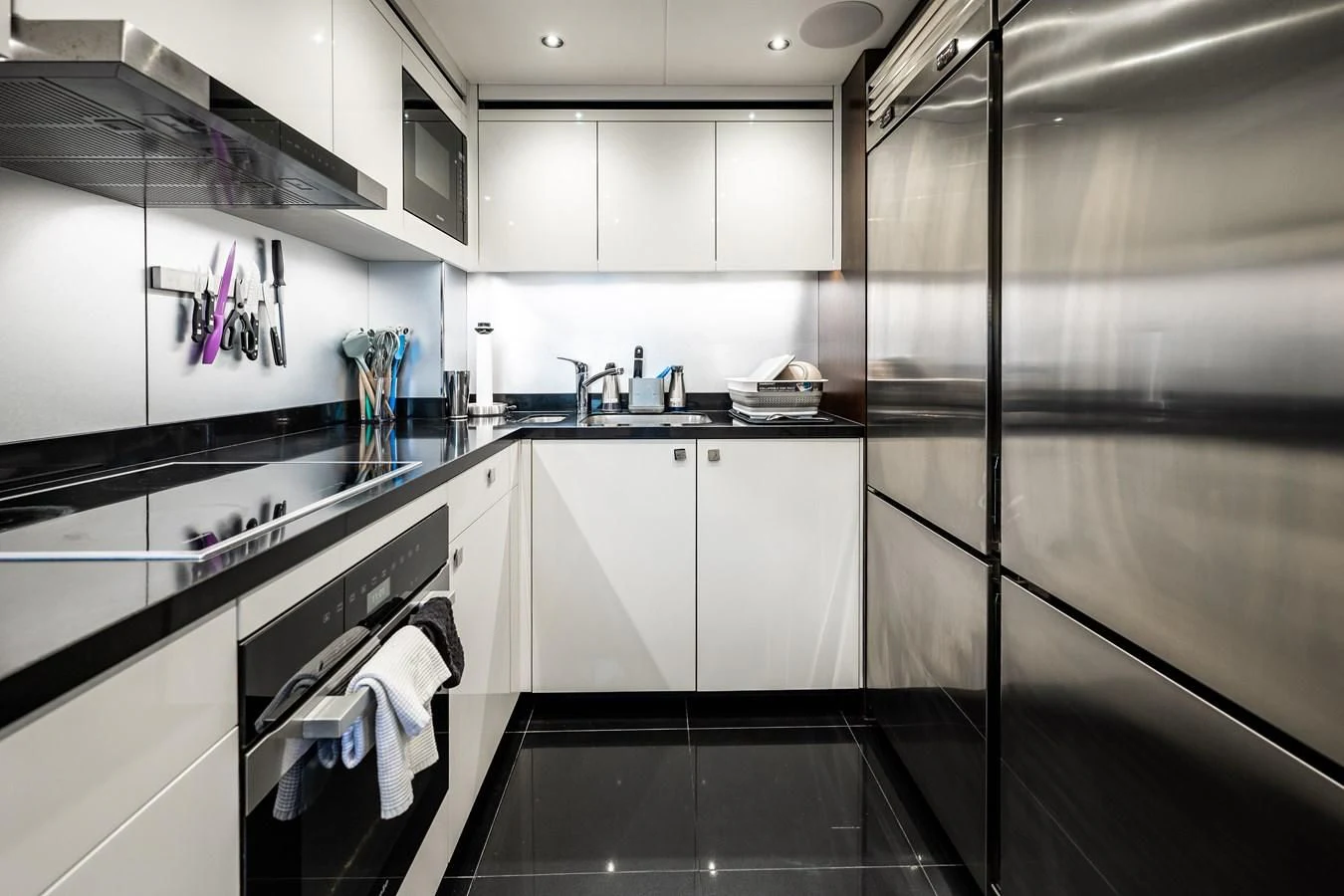 a kitchen with white cabinets aboard ROMANI Yacht for Sale