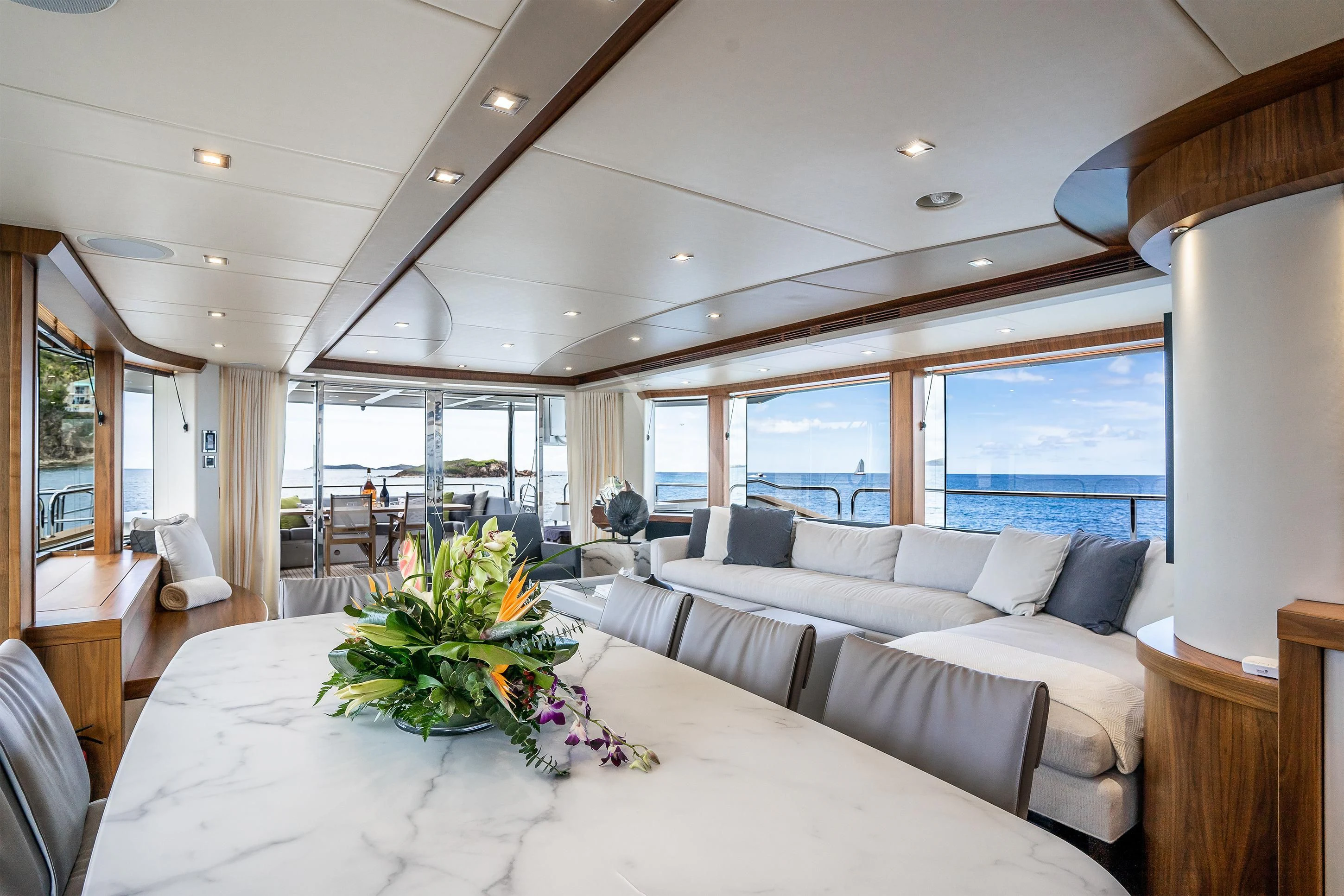 a large living room with a large white table and white couches aboard ELITE Yacht for Sale