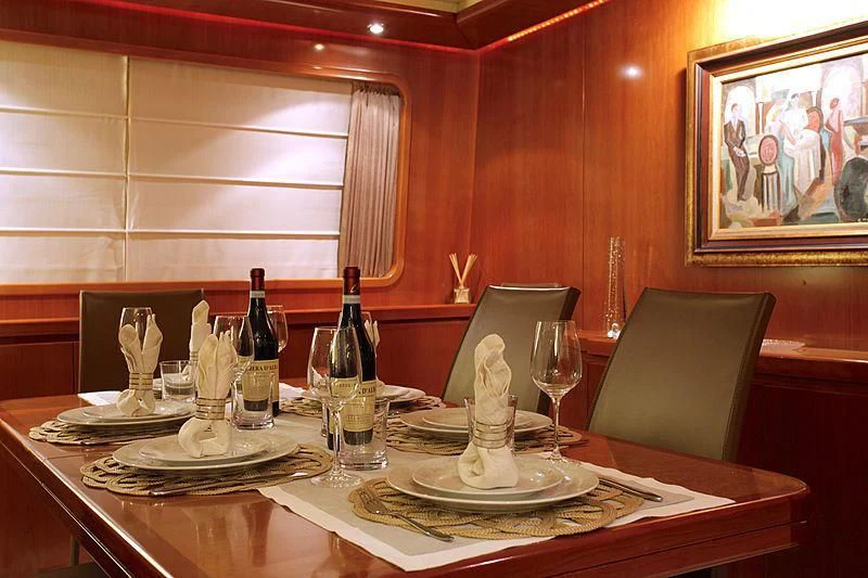 a table with plates and wine bottles aboard SOHO Yacht for Sale