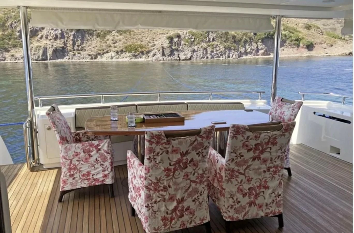 a table and chairs on a deck overlooking a body of water aboard NIKE III Yacht for Sale