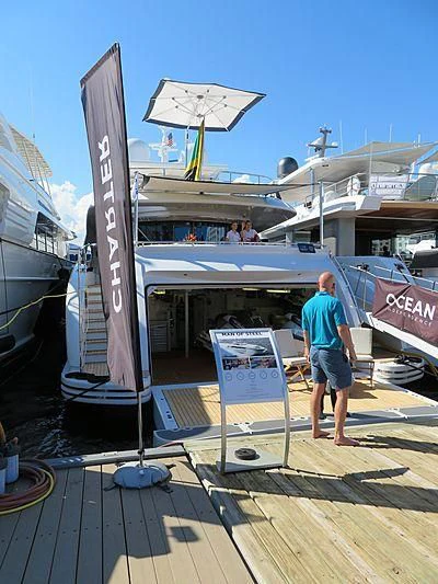 a person standing next to a surfboard aboard LUMIR Yacht for Sale