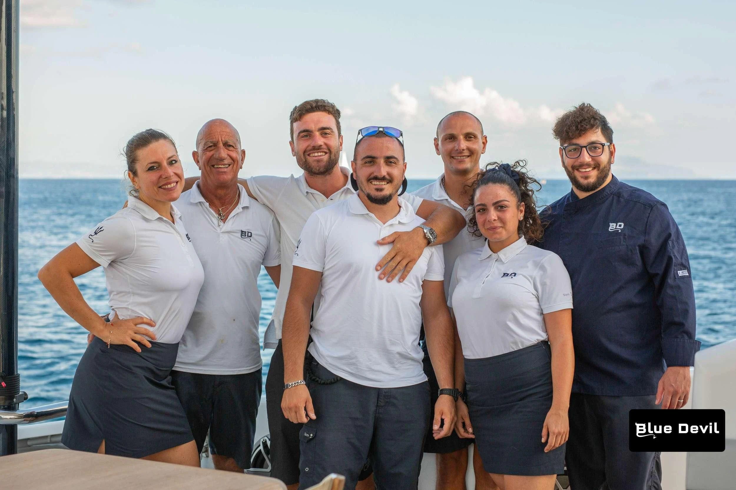 a group of people posing for a photo aboard BLUE DEVIL Yacht for Sale