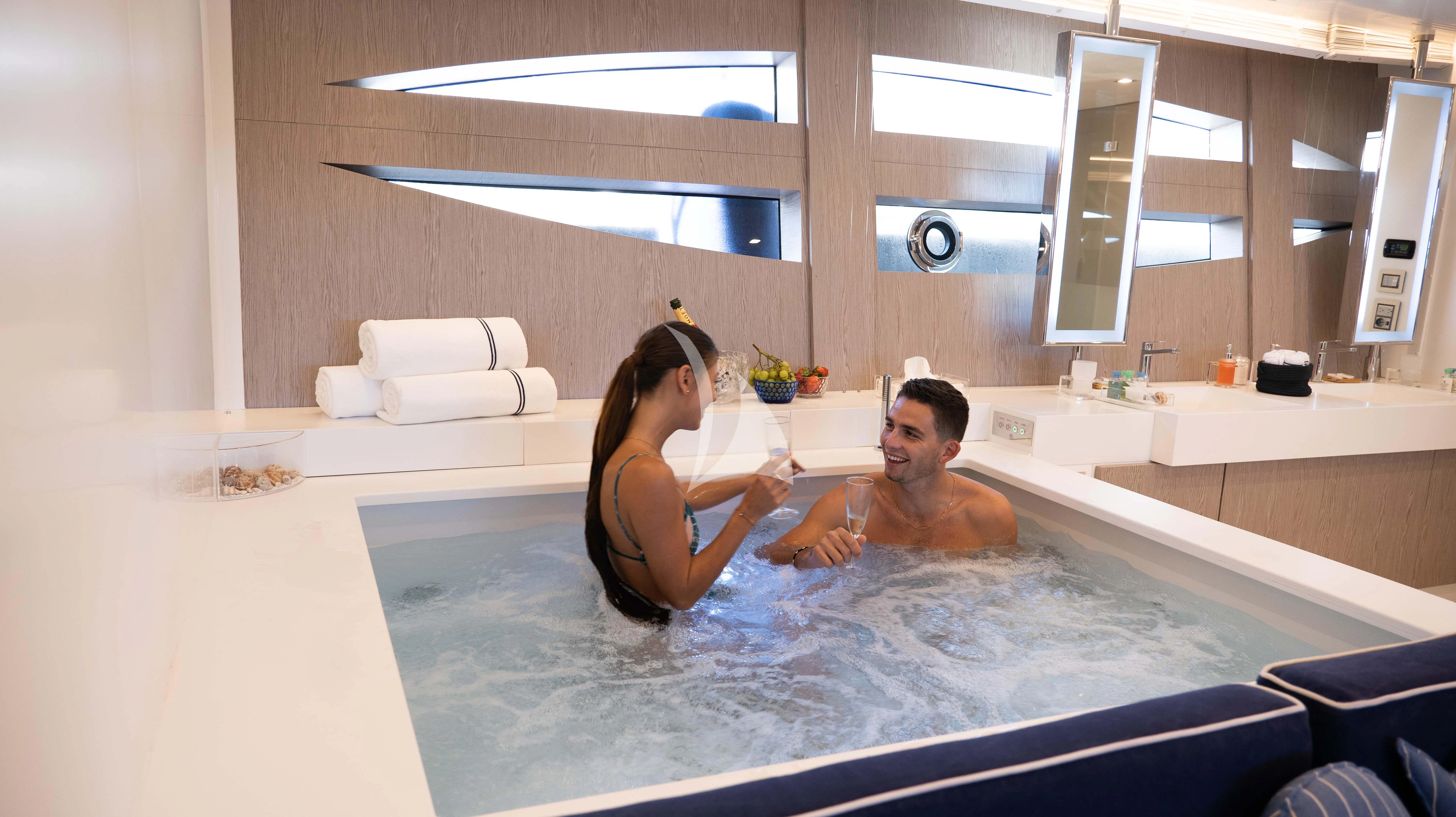 a man and woman sitting in a bathtub aboard BLUE DEVIL Yacht for Sale